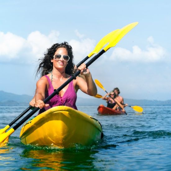 Coppie in kayak che remano in zona Posillipo, Napoli.