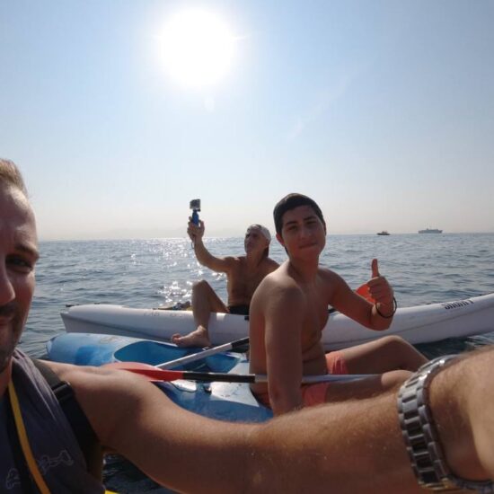 Gruppo di escursionisti in kayak, fanno una foto sulle rive della costa di Posillipo, Napoli